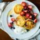 A cozy breakfast scene with scrambled eggs, whole-grain toast, mixed berries, and a steaming mug of coffee on a rustic wooden table.