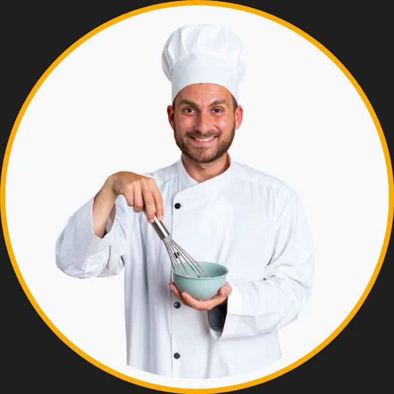 Professional chef plating a gourmet dish in a modern kitchen, smiling confidently at the camera